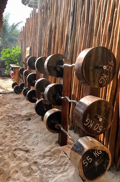 a row of wooden barrels sitting next to each other on top of a sandy beach