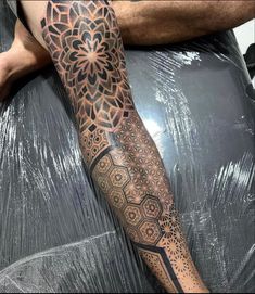 a man's arm with an intricate tattoo design on the forearm and leg area