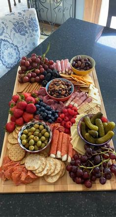 a wooden cutting board topped with different types of food and snacks on top of it