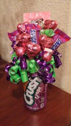 a can filled with candy and candies sitting on top of a wooden table next to a wall