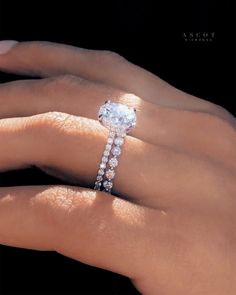 a woman's hand with a diamond ring on her finger and an engagement band