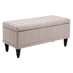 an upholstered bench with black legs and a light colored fabric cover on it