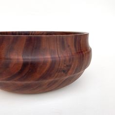 a wooden bowl sitting on top of a white table