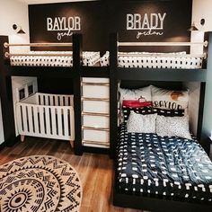 two bunk beds with black and white bedding are next to a baby crib