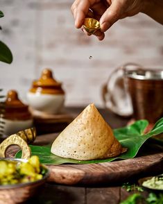 a person is sprinkling some sort of food on top of a wooden table