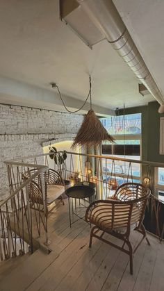 a room with wooden floors and chairs on the top floor next to a brick wall