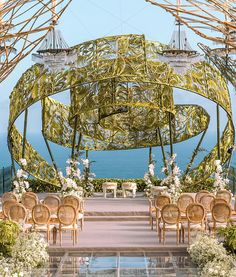 an outdoor ceremony set up with chairs and flowers on the aisle, overlooking the ocean