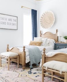 a bed room with two beds sitting next to each other on top of a rug