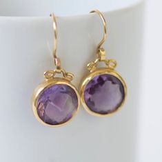 "𝗪𝗔𝗡𝗧 𝟭𝟬% 𝗢𝗙𝗙 𝗧𝗢𝗗𝗔𝗬? Get your code at https://bit.ly/2Jlkfoz (Just copy and paste that into your browser.). --------------------------------------------------------------- Elegant 18k gold round dangle earrings with round faceted amethyst pendants. The settings encircle the gemstones delicately so that the light can travel through them and reveal the beauty of the purple color. They have great movement and will definitely be an asset to every outfit. Amethysts have always had a par Silver Cuff Ring, Handmade Wedding Rings, Round Dangle Earrings, Drop Earrings Gold, Sterling Silver Mens Rings, 18k Gold Earrings, Birthstone Earrings, Solid Gold Earrings, Precious Jewels