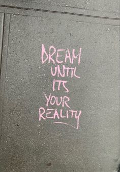 graffiti on the side of a building reads, dream until it's your reality