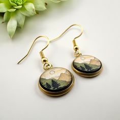 Celebrate your 5th anniversary with a touch of nature and elegance with our Mountain Landscape Dangle Earrings. Handcrafted from the finest wood, these lightweight earrings capture the serene beauty of forested mountains, making them a perfect gift for the special woman in your life. The intricate design showcases a stunning mountain range, evoking a sense of adventure and tranquility. These earrings are not only a symbol of your love and the journey you've shared but also a fashionable accessor Nature-inspired Hoop Earrings As Gift, Nature-inspired Round Hoop Earrings For Gift, Nature-inspired Dangle Hoop Earrings As Gift, Nature-inspired Dangle Hoop Earrings, Nature-inspired Dangle Hoop Earrings For Gift, Nature-inspired Drop Earrings With Lever Back Ear Wires, Nature-inspired Round Brass Earrings, Hypoallergenic Nature-inspired Round Earrings, Gold Nature-inspired Earrings For Everyday