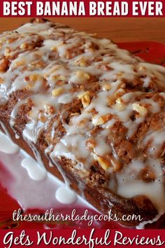 a loaf of banana bread with white icing on a red and white platter