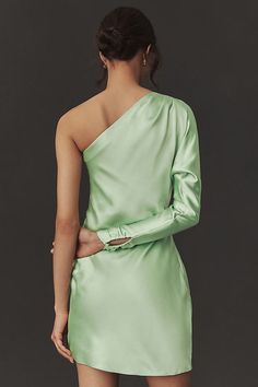 Rendered in stretch polyester satin, this sleek dress is sure to turn heads. The unique one-shoulder design paired with a sophisticated long sleeve offers an intriguing blend of elegance and subtle allure. Ruched detailing at the hip enhances the shape with a touch of sculptural artistry to the overall silhouette. | Lucy Stretch Satin One-Shoulder Mini Dress by BHLDN in Green, Women's, Size: 16, Polyester/Satin at Anthropologie Fitted One Shoulder Dress With Satin Finish For Party, One Shoulder Satin Evening Dress, Glamorous Satin One-shoulder Dress With Asymmetrical Neckline, Fitted One-shoulder Satin Cocktail Dress, Fitted One-shoulder Satin Dress For Night Out, Evening Satin One Shoulder Top, Fitted Satin One Shoulder Cocktail Dress, One-shoulder Satin Dress For Spring Party, One-shoulder Satin Dress For Date Night In Spring