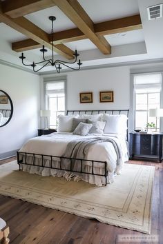 a bedroom with white walls and wood beams