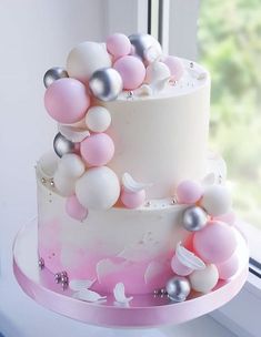 a white and pink cake sitting on top of a window sill