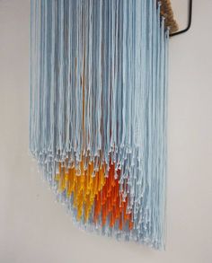 an art piece made out of yarn hanging on a wall