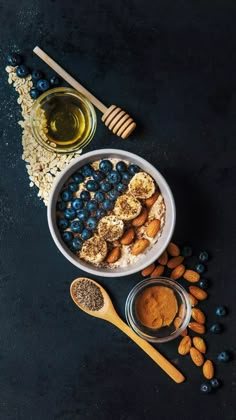 blueberries, almonds, and honey are in bowls next to some oatmeal