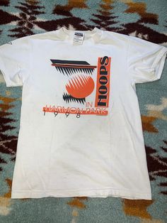 Vintage 1998 SPORTS TEE (SMALL) Description: Relive the iconic vibes of the late '90s with this vintage 1998 graphic t-shirt. Made from soft, breathable cotton, this tee features a retro design that captures the essence of the era. Whether you're a '90s kid or just appreciate timeless style, this shirt is a must-have addition to your collection. Grab it now and infuse your wardrobe with a dose of nostalgia! Specifications: Year: 1998 Material: 100% cotton Color: Faded white Design: "Nostalgia Cl Sporty T-shirt For Spring Fan Merchandise, Retro Sports T-shirt With Graphic Print, Throwback Sports T-shirt With Screen Print, 90s Style White Graphic Print T-shirt, 90s Style Short Sleeve Sports T-shirt, 90s Sports T-shirt For Summer, Casual Graphic T-shirt For Sports Events, Graphic Tee With Logo Print For Sports Season, Urban Tops With Graphic Print For Sports Season