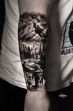 a man's arm with a mountain scene on it