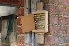 a bird house built into the side of a brick building with holes in it's roof