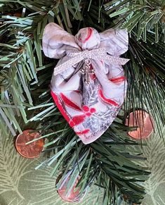 an ornament hanging from a christmas tree with coins on the ground next to it