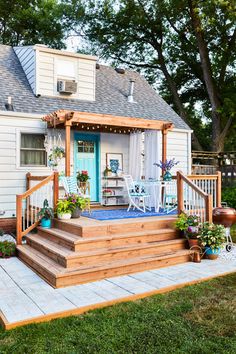 a porch with steps leading up to the front door and covered in blue rugs