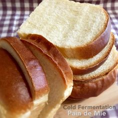 a close up of bread slices on a cutting board with a checkered cloth in the background