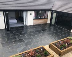 an outdoor patio area with raised planters and plants in the foreground, leading to a bedroom