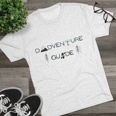 Dads will love to wear this t-shirt showing everyone how much they love to enjoy the outdoors with their kids! Dads lead us in all kinds of adventures, through the woods and the mountains and waters, hiking and climbing and kayaking, enjoying time with their kids! Celebrate being an adventure Dad with this Dadventure Guide shirt! This high quality regular fit tee has a casually elegant vibe. Additionally, unbelievably soft tri-blend fabric makes it extremely comfortable - once put on, impossible to take off. .: 50% polyester, 25% combed ringspun cotton, 25% rayon .: Light Fabric (4.3 oz/yd (146 g/m)) .: Regular fit .: Sewn-in label Short Sleeve Graphic Tee For Outdoor Activities, Pre-shrunk Tri-blend T-shirt For Outdoor Activities, Graphic Tee For Outdoor Activities With Moisture-wicking, Outdoor Graphic Tee With Moisture-wicking, Graphic Tee Shirt With Short Sleeves For Outdoor Activities, Casual Tri-blend T-shirt For Adventure, Short Sleeve Moisture-wicking Shirt For Outdoor Activities, Moisture-wicking Graphic Tee For Outdoor Activities, Moisture-wicking Short Sleeve Shirt For Outdoor Activities