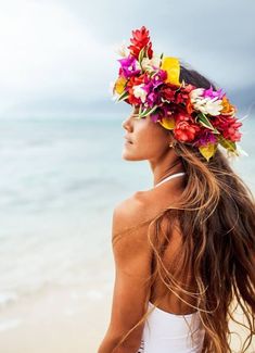 a woman with flowers in her hair on the beach