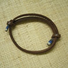 Handmade Leather Bracelet In Dark Brown. Knots Slide To Adjust Fit. Ends Are Wrapped With 3 Shades Of Blue. For Women Or Men. Simple Design. New Item From My Local Shop. Great For Any Occasion. Tags: Bracelet, Adjustable, Leather, Handmade, Handcrafted, Unisex, Mens, Womens, Casual, Everyday, Hippie, Rustic, Western, Primative Adjustable Brown Bracelet, Adjustable Brown Bracelets For Everyday Use, Brown Handmade Leather Bracelet With Waxed Cord, Adjustable Blue Leather Bracelet, Adjustable Blue Leather Bracelet For Everyday, Brown Adjustable Wrap Bracelet For Everyday, Bohemian Brown Leather Bracelet For Everyday Use, Brown Bohemian Leather Bracelet For Everyday Use, Brown Bohemian Leather Bracelet For Everyday