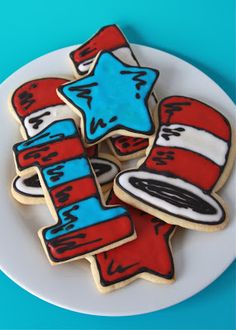 dr seuss hat and stars decorated sugar cookies on a white plate with blue background