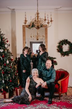 a man and woman sitting in front of a christmas tree