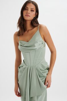 a woman in a green dress posing for the camera