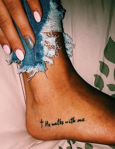 a woman's foot with the words, he walks with me tattooed on it