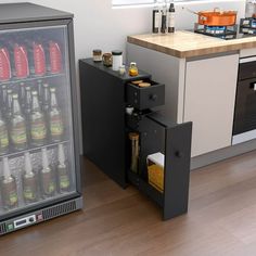 an open refrigerator in the middle of a kitchen next to a counter with bottles on it