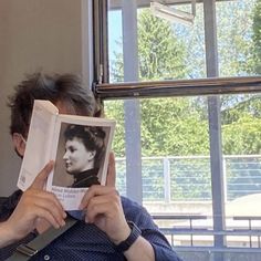 a man holding up an old photo to his face