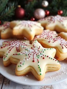 several decorated cookies on a plate next to a christmas tree