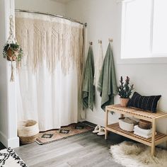 a bathroom with two towels hanging on the wall and a bench in front of it