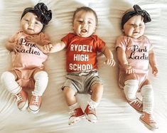 three baby babies laying on top of a bed