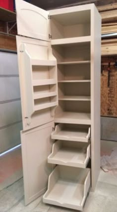 an open white cabinet with shelves and drawers