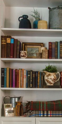 the bookshelves are filled with many different types of books and vases on them