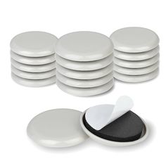 a stack of white plates next to a black and white container with a piece of paper sticking out of it