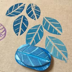 a close up of a blue leaf on a canvas bag with other items in the background