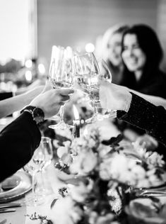 black and white photograph of people toasting with wine glasses