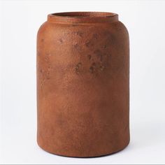 a brown vase sitting on top of a white table