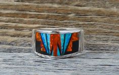 This band ring is handcrafted with Sterling Silver and beautifully inlaid with bright , dazzling, Fire Lab Opal and Onyx. As is seen in this work of art, the artist's talent is evident! It is a favorite due to the expertly clean cut geometric work, followed by the angular shape of the ring. This is that signature accessory that will compliment your wardrobe. We are proud to offer the David Rosales Collection of fine Native American Indian Jewelry. He has built a reputation for the finest inlaid Artisan Rings With Inlay For Anniversary, Unique Multicolor Rings With Polished Finish, Multicolor Inlay Rings For Anniversary, Unique Opal Ring With Inlay For Gift, Anniversary Multicolor Inlay Rings, Artisan Multicolor Rings With Inlay, Unique Sterling Silver Opal Inlay Ring, Artisan Multicolor Inlay Rings, Unique Sterling Silver Opal Ring With Inlay