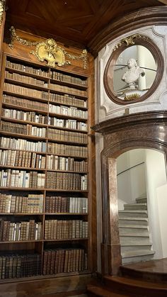 an old library with many books on the shelves and a mirror in front of it