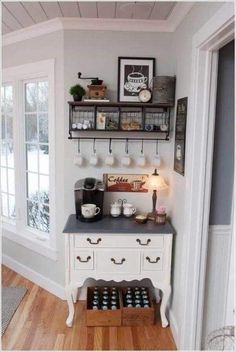 a kitchen with white cabinets and shelves filled with wine bottles on top of wooden floors