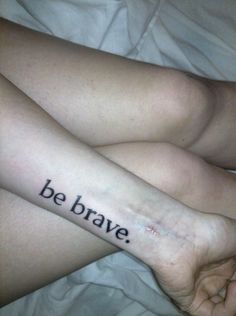 a person with a tattoo that says be brave